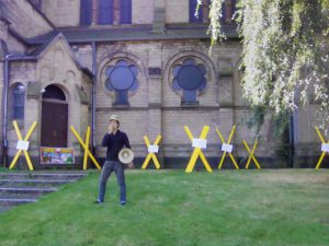 Aktivist*innen markieren symbolisch die Kirche in Immerath als Ort, der abgebaggert werden soll mit gelben Xen. Vor Ort wird auch Theatherstück aufgeführt.